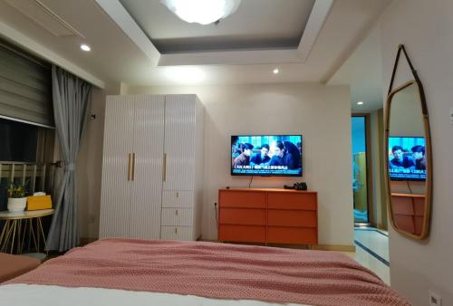 a bedroom with a bed with a tv on the wall at Shanghai Lerongju Boutique Apartment Metro Line 8 20meter in Shanghai