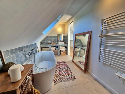 a bathroom with a large tub and a mirror at 727-Superbe vue mer, grand confort, les pieds dan in Primelin