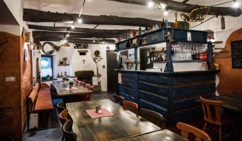 a restaurant with two tables and a bar at Penzion za mlynom in Bešeňová