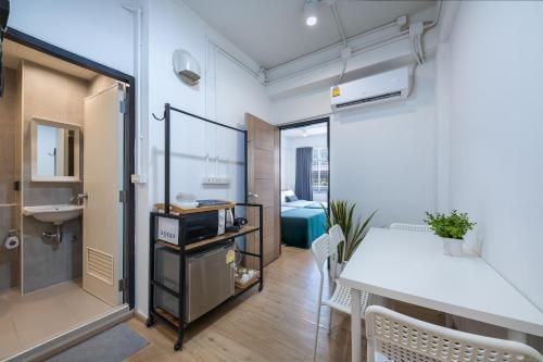 a room with a table and a sink and a bathroom at Platinum Deluxe Shopping Apartments in Bangkok