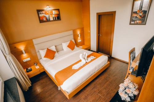 a bedroom with a bed with two towels on it at Imperial Heights in Deoghar