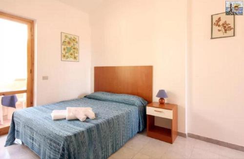 a bedroom with a bed with a towel on it at Residence Capo San Marco & Renella in Sciacca