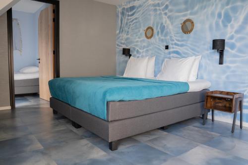 a bedroom with a large bed with a blue wall at Othmar Herberg in Ootmarsum