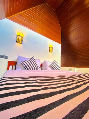a bedroom with a large bed with a wooden headboard at Cloudy Hill Cottage in Ella