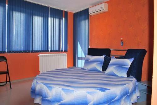 a bedroom with a bed with blue and orange walls at Hotel Milenium in Sofia