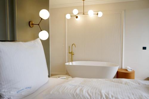 a bedroom with a bath tub and a bed at ApartPark by Baltic Home in Świnoujście