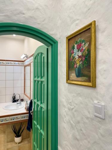 a bathroom with a painting of a vase of flowers at Tia Maria in Győr