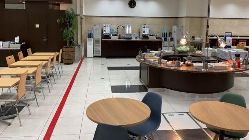 a restaurant with tables and chairs and a counter at Toyoko Inn Tokyo Shinagawa Konan-guchi Tennozu Isle in Tokyo