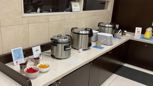 a counter with two kettles and bowls of food at Toyoko Inn Tokyo Shinagawa Konan-guchi Tennozu Isle in Tokyo