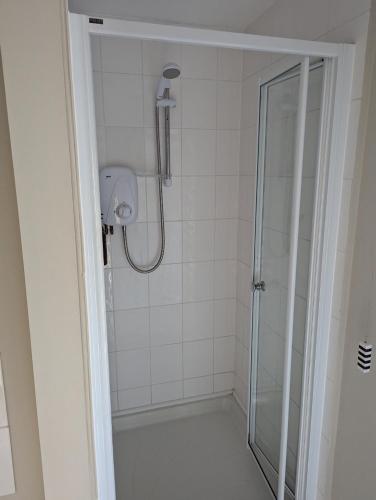 a bathroom with a shower with a glass door at The Duke Hotel in Hilmarton