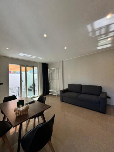 a living room with a couch and a table and chairs at IG - "Villa Don Antonio" Apartments in Giardini Naxos