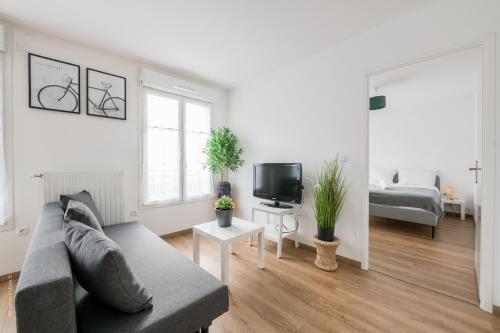 un salon avec un canapé et une télévision dans l'établissement Feel Good by Plaza proche Disneyland Paris, à Chessy