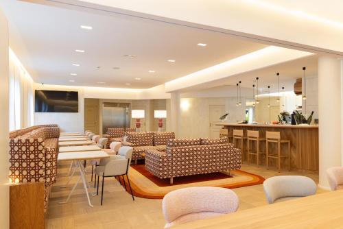 a restaurant with chairs and tables and a kitchen at Le Plessis Grand Hotel in Le Plessis-Robinson