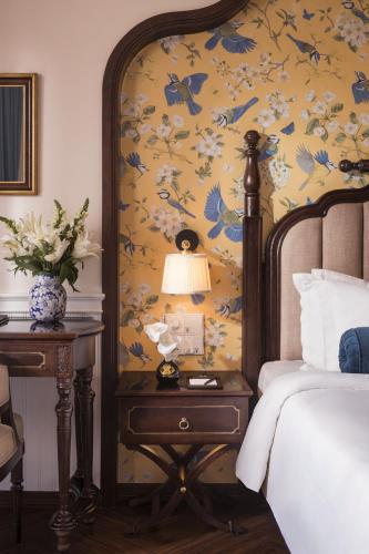 a bedroom with a bed and a table with a lamp at Hanoi Tirant Hotel in Hanoi