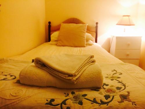 a bed with a blanket and pillows on it at Southend Inn Hotel - Close to Beach, Train Station & Southend Airport in Southend-on-Sea