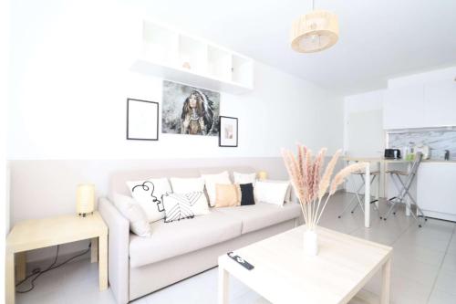 un salon blanc avec un canapé et une table dans l'établissement Sweety By Plaza - Proche Disneyland, à Chessy