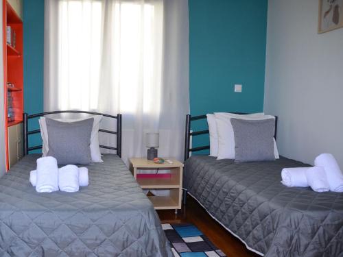 two beds in a room with blue walls at V for Vacation in Ioannina
