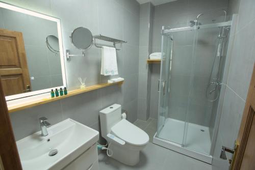 a bathroom with a shower and a toilet and a sink at Khangain Tugul Hotel in Tsetserleg