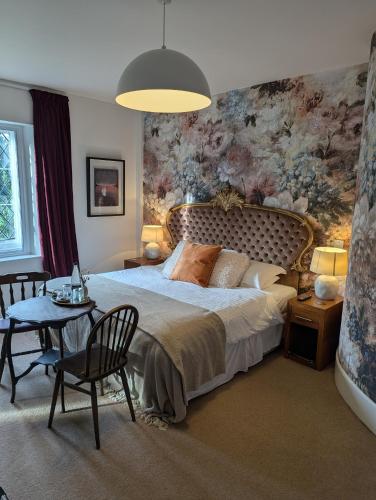 a bedroom with a large bed and a table and chairs at The Duke Hotel in Hilmarton