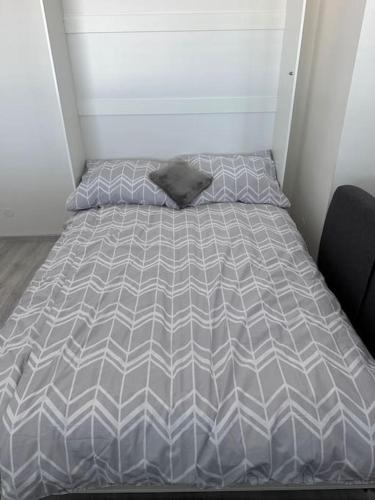 a bed with a gray comforter in a room at Apartman Komenského-Centrum in Banská Bystrica