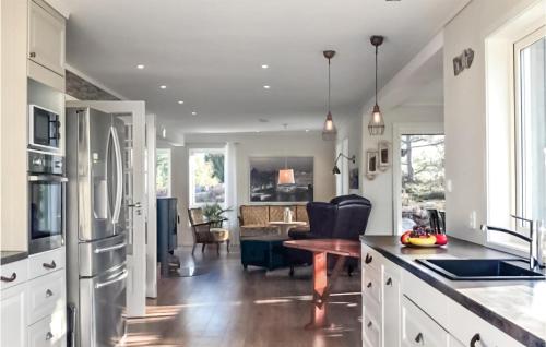 a kitchen with white cabinets and a living room at Stunning Home In Nordre Frogn in Nordre Frogn