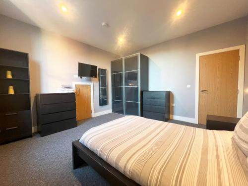 a large bedroom with a bed and a dresser at 1 bed Apt close to Leeds Arena Sleeps up to 4 people F1 in Leeds
