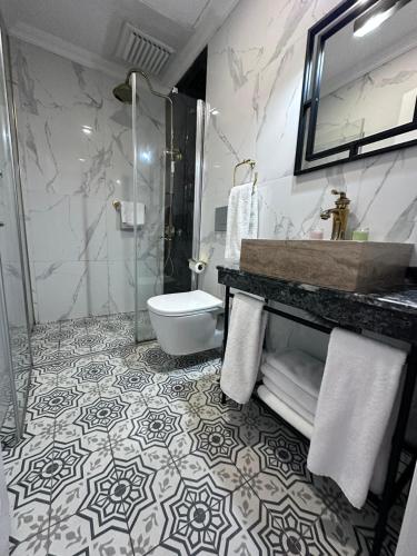 a bathroom with a shower and a toilet and a sink at The Independent Hotel Taksim in Istanbul