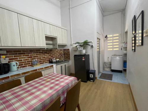 a kitchen with a table and a refrigerator at ZD Homestay Pekan in Pekan