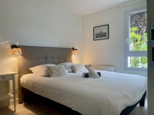 une chambre avec un grand lit blanc avec deux oreillers dans l'établissement Alma Square by Plaza - proche Disneyland Paris, à Magny-le-Hongre