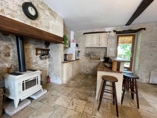 a kitchen with a fireplace and a stove at La métairie basse Dordogne 2 Gites pour 18 personnes au total in Saint-Aubin-de-Nabirat