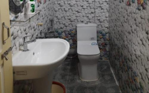 a bathroom with a white toilet and a sink at Simma Homestay By StayApart in Pedong