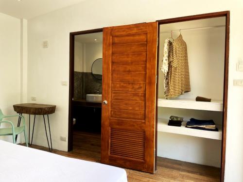 a closet with a wooden door in a bedroom at AQUA Boutique Resort & Pool in Ko Phayam