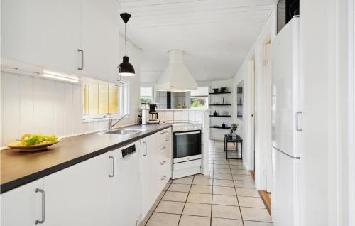 a white kitchen with a sink and a counter at Holiday Home Æblehaven Hejls Xi in Hejls
