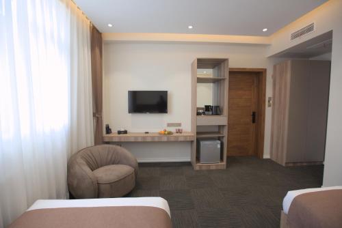 a hotel room with a bed and a chair and a television at Khangain Tugul Hotel in Tsetserleg