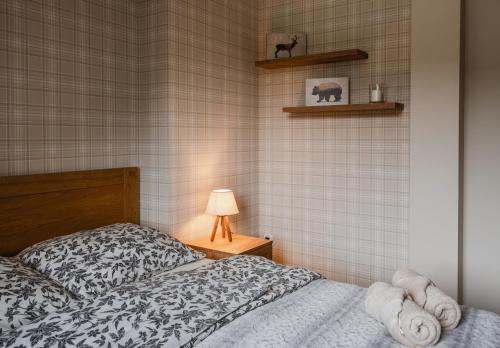 a bedroom with a bed and a lamp on a table at Bacówka Polany in Polany