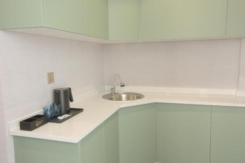 a kitchen with a sink and a counter with white cabinets at Khangain Tugul Hotel in Tsetserleg