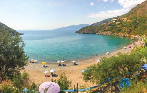 a beach with umbrellas and people in the water at Maison Elia With Private Pool in Kardamili
