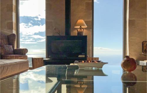 a living room with a tv and a glass table at Maison Elia With Private Pool in Kardamili