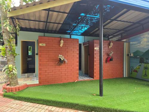 a house with a brick wall and a pole at Campchamao in Ban Ra-ok