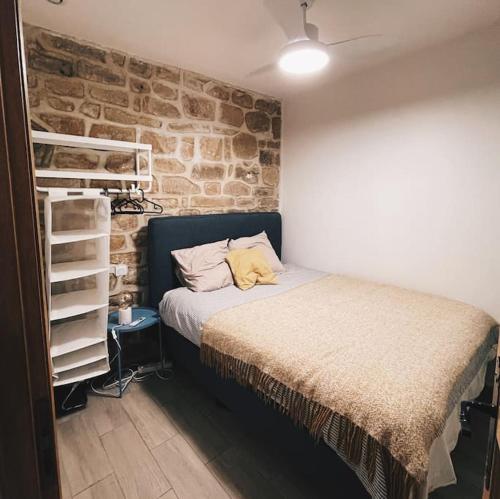 une chambre avec un lit et un mur de briques dans l'établissement Lovely apartment in Louvre, à Paris