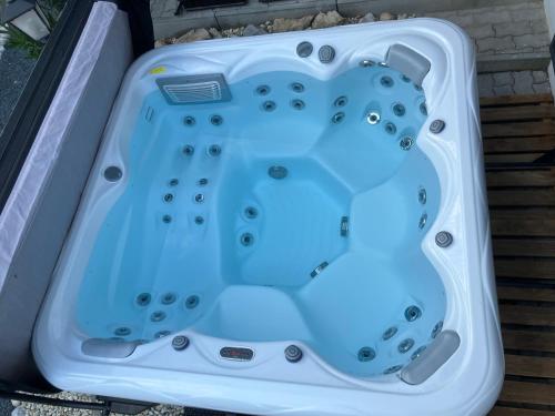 a bath tub with a blue light in it at Relax Apartman in Sümeg
