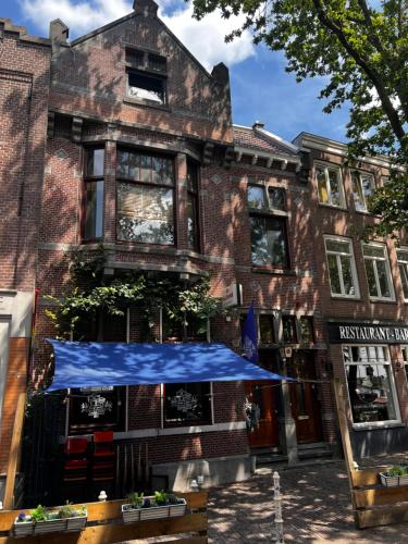 a building with a blue umbrella in front of it at Boutique Hotel de Kade Zaandam-Amsterdam in Zaandam