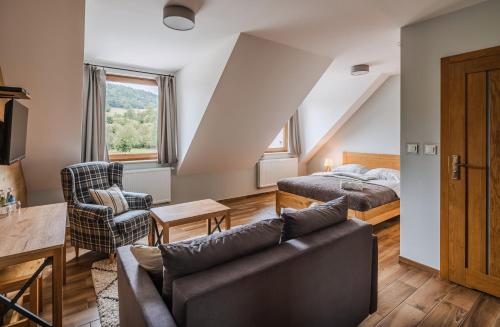 a living room with a couch and a bed at Bacówka Polany in Polany