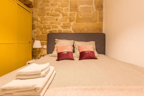 une chambre avec un lit avec deux oreillers rouges dans l'établissement Beautiful apartment in Louvre Museum, à Paris