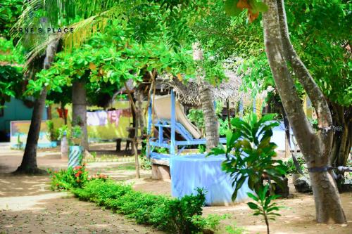 a blue bench sitting in a park with trees at Arne's Place in Arugam Bay