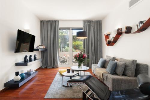Una sala de estar con un sofá y un televisor. en Serena Calm Pool House, en Atenas