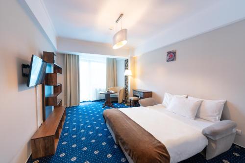 a hotel room with a bed and a television at Hotel Ski&Sky in Predeal