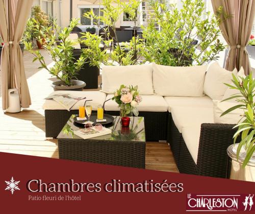 a living room with a white couch and a table at Logis Hotel - Le Charleston in Le Mans