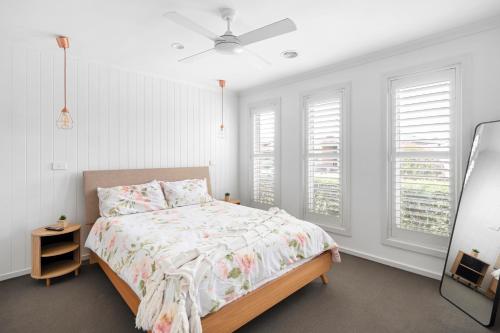 Un dormitorio con una cama y dos ventanas. en City and Sea Retreat - Family Friendly Stay, en Marshalltown