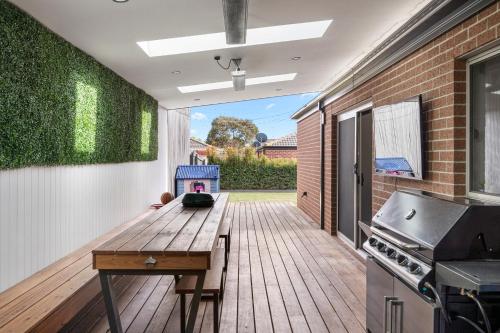 a kitchen with a wooden table on a deck at City and Sea Retreat - Family Friendly Stay in Marshalltown